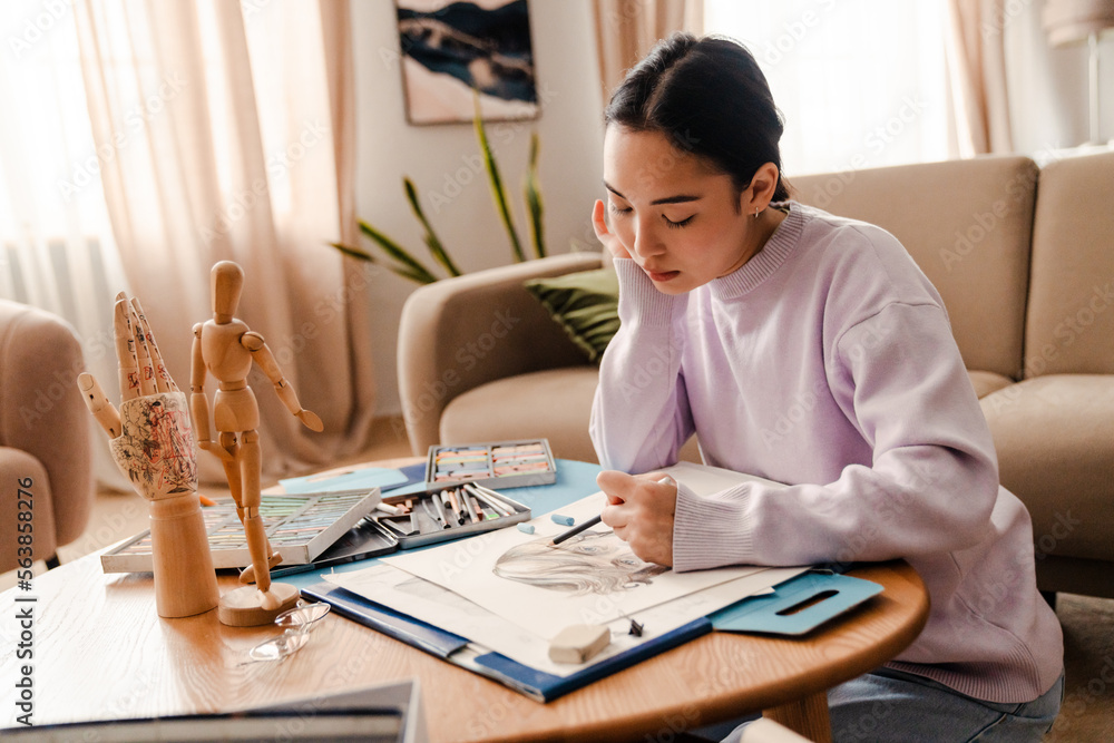 Asian woman artist drawing portrait with pencil at home Asian woman artist drawing portrait with pencil at home