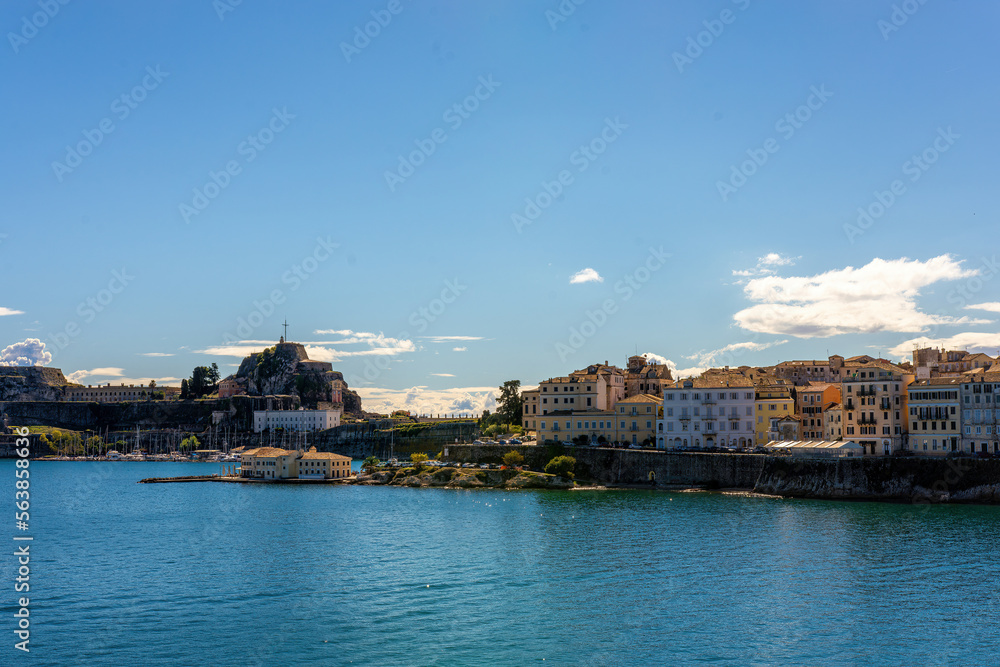 Kerkyra cityscape. Corfu island, Greece. Sea bay with calm turquoise water and colorful old houses.