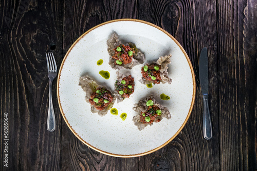 tartare in chips in a plate on a dark background
