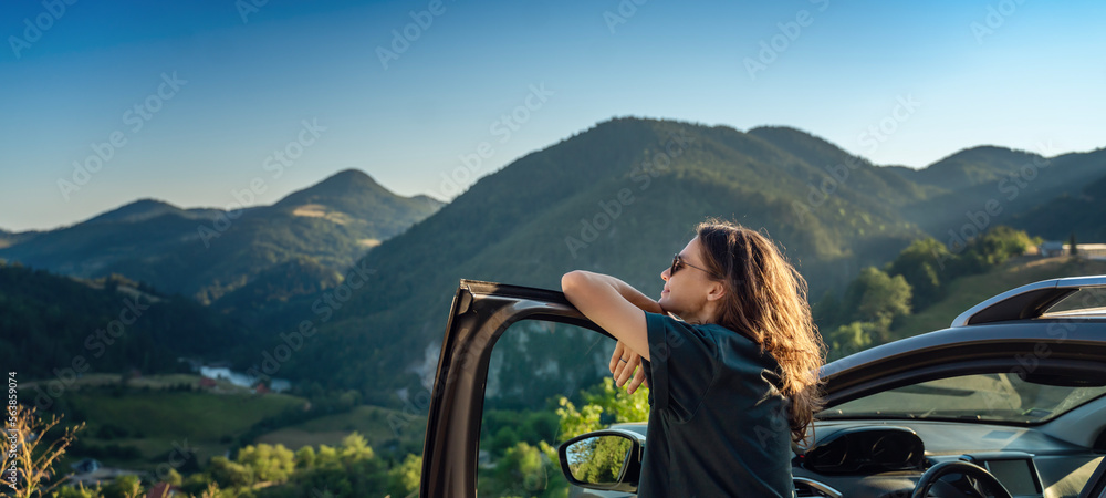 Young beautiful woman traveling by car in the mountains, summer vacation - obrazy, fototapety, plakaty 