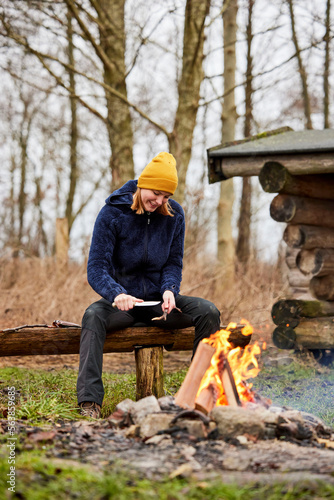 female in nature sitting and cutting wood