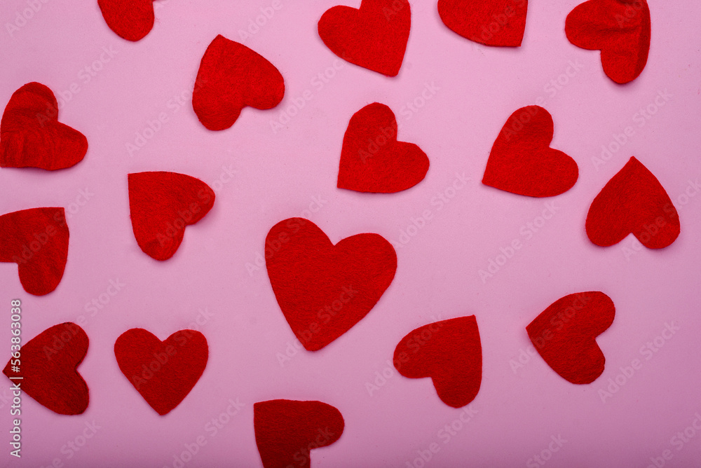 Heart-shaped felt figures on a pink background. Valentine's Day background.