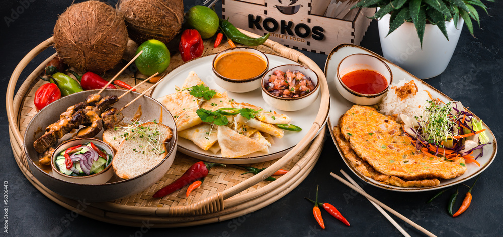 Set of restaurant dishes: beef kebab, omelette with tomatoes and onions, flatbread with cheese filling on dark. Set of restaurant dishes: beef kebab, omelette with tomatoes and onions, flatbread with cheese filling on dark.