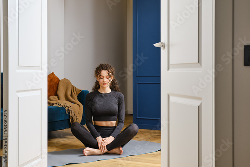 Young woman practicing breathing exercise at home