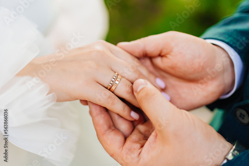 a man's hand holds a woman's hand with a wedding ring on her finger. 