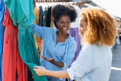 African american woman talking with client at flea market