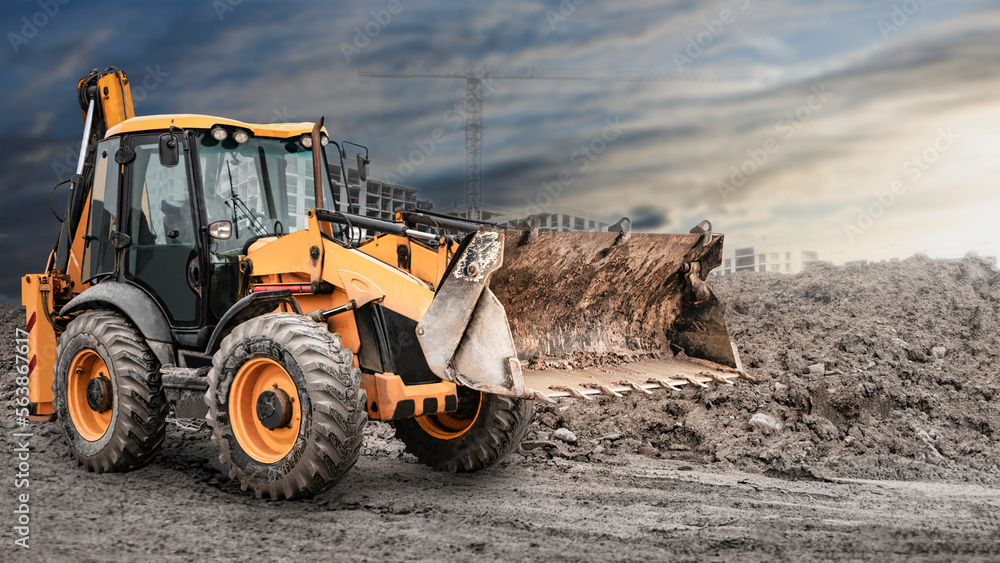 Bulldozer or loader at a construction site shovels mountain soil into a heap. Powerful wheel loader or bulldozer with a large bucket at a construction site. Construction equipment for earthworks. Bulldozer or loader at a construction site shovels mountain soil into a heap. Powerful wheel loader or bulldozer with a large bucket at a construction site. Construction equipment for earthworks.