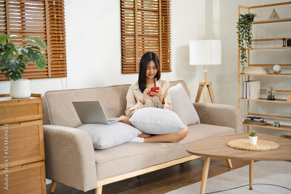 Asian girl using cell phone for checking social media at home holding smartphone in morning. Asian girl using cell phone for checking social media at home holding smartphone in morning.