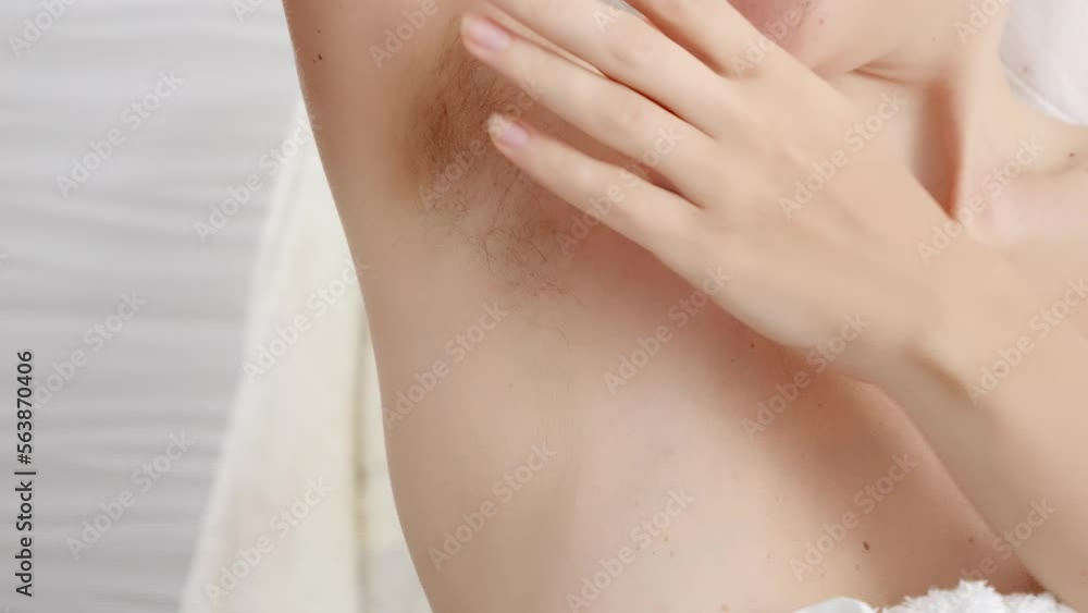 Closeup of long dark hair growing under arm of young female. Concept of hygiene, natural beauty, feminity and body hair growth Closeup of long dark hair growing under arm of young female. Concept of hygiene, natural beauty, feminity and body hair growth