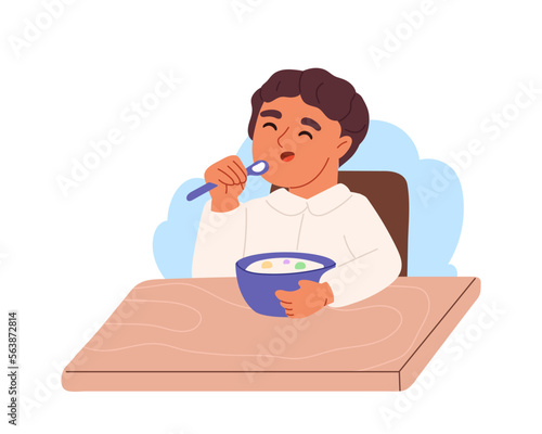 Kid boy eating porridge on breakfast. Small child enjoy muesli with milk meal before school