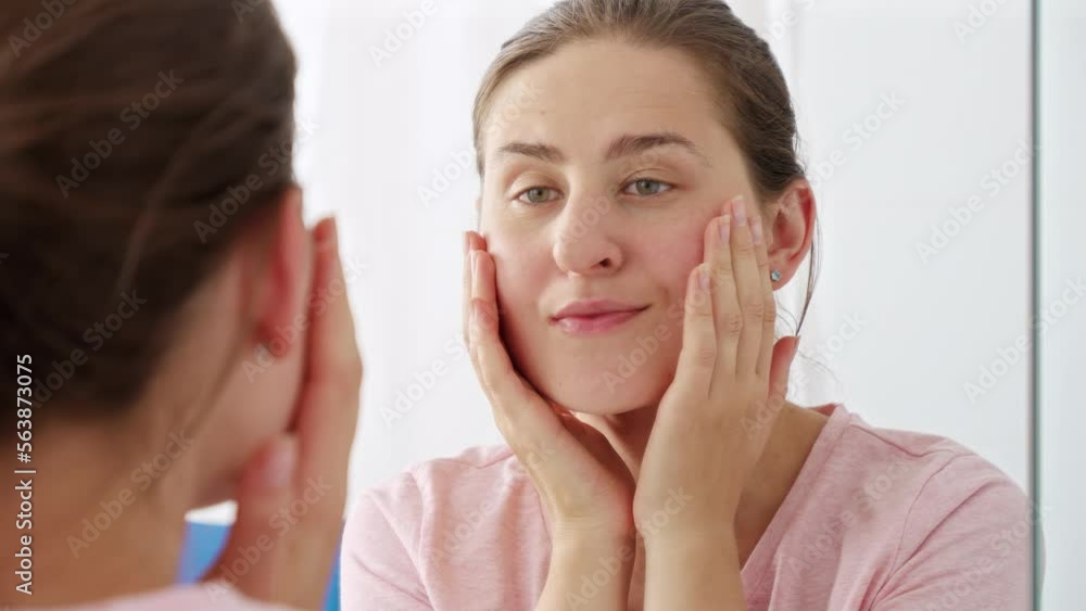 Portrait of beautiful young woman with perfect skin checking for wrinkles and face issues. Concept of female aging, skin issues, facial treatment and care Portrait of beautiful young woman with perfect skin checking for wrinkles and face issues. Concept of female aging, skin issues, facial treatment and care
