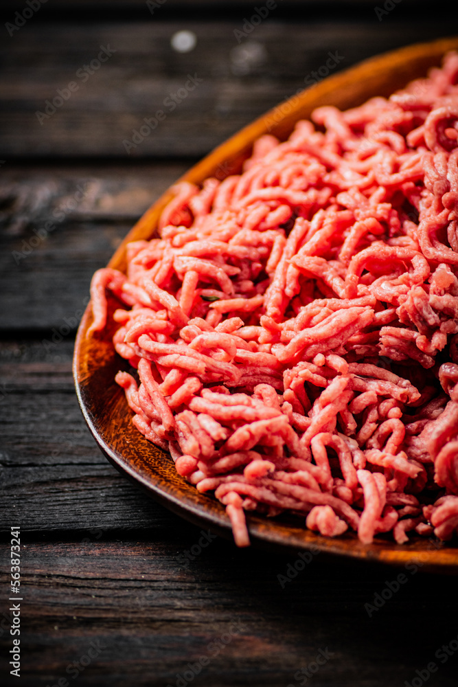 A wooden plate full of minced meat. A wooden plate full of minced meat.