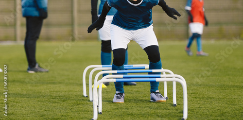 Winter Football Soccer Training Camp. Player in Soccer Winter Clothes on Training with Hurdles. Athlete Player Practice Hurdle Jump