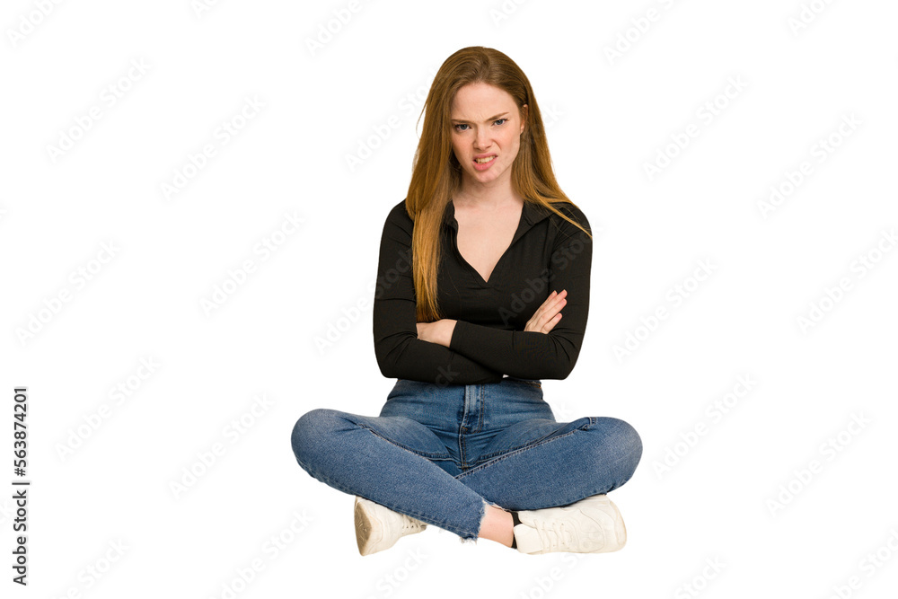 Young redhead woman sitting on the floor cut out isolated keeping eyes opened to find a success opportunity. Young redhead woman sitting on the floor cut out isolated keeping eyes opened to find a success opportunity.