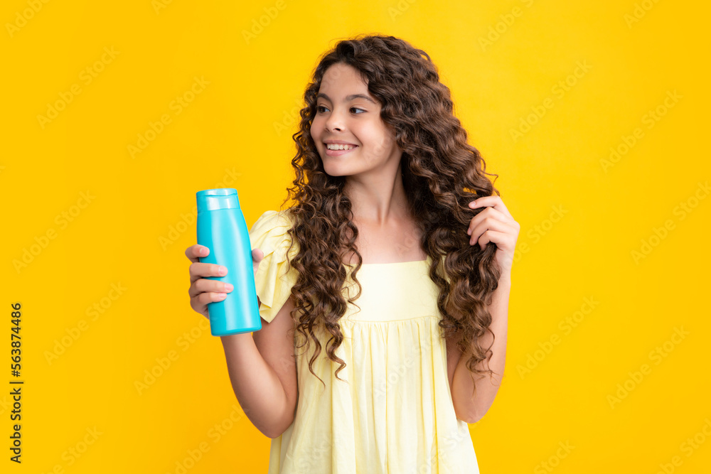 Happy portrait of child with shampoo conditioner. Daily cosmetic care. Teenager kid 12, 13, 14 years old hold bottle of hair and skin care. Beauty health and cosmetics. Smiling girl. Happy portrait of child with shampoo conditioner. Daily cosmetic care. Teenager kid 12, 13, 14 years old hold bottle of hair and skin care. Beauty health and cosmetics. Smiling girl.