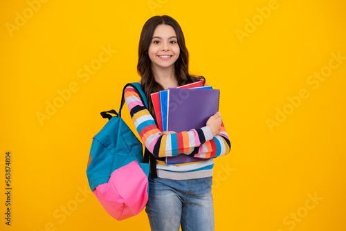 School teenager child 12, 13, 14 years old with book and copybook. Teenager schoolgirl on isolated background. Learning and knowledge education concept. Happy teen girl.