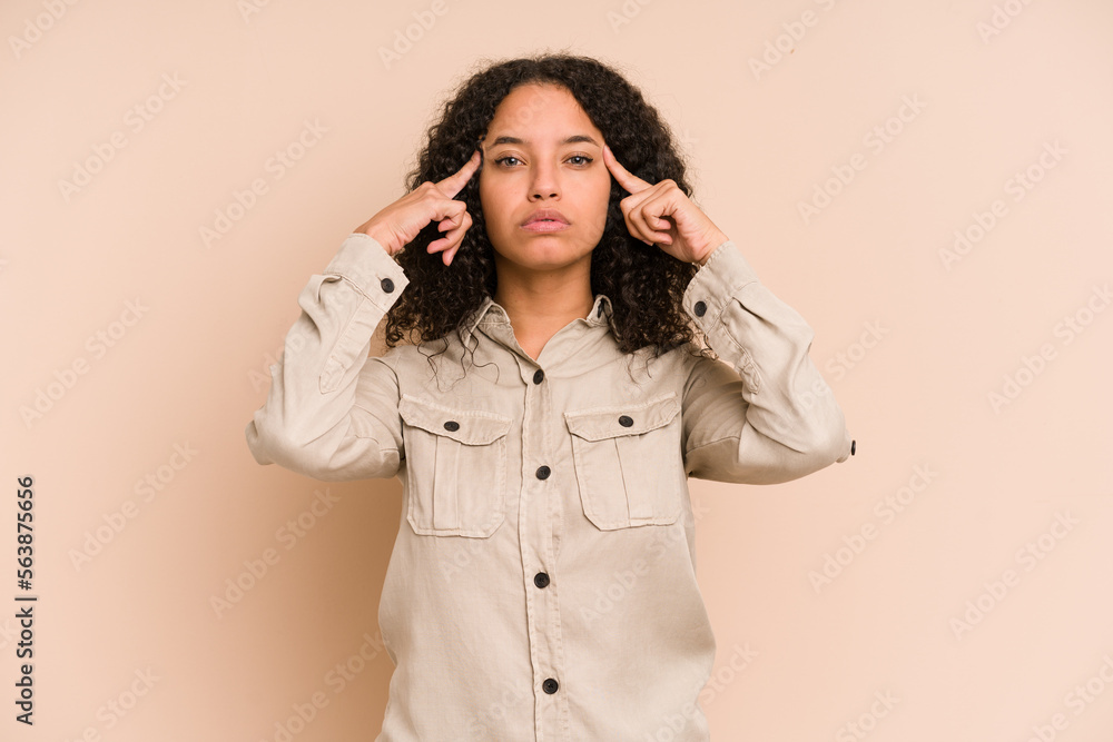 Young african american curly woman isolated focused on a task, keeping forefingers pointing head. Young african american curly woman isolated focused on a task, keeping forefingers pointing head.