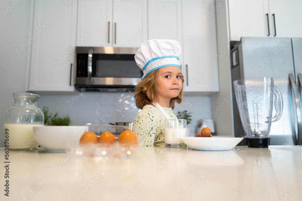 Kid chef cook cookery at kitchen. Cooking, culinary and kids. Little boy in chefs hat and apron. Kid chef cook cookery at kitchen. Cooking, culinary and kids. Little boy in chefs hat and apron.