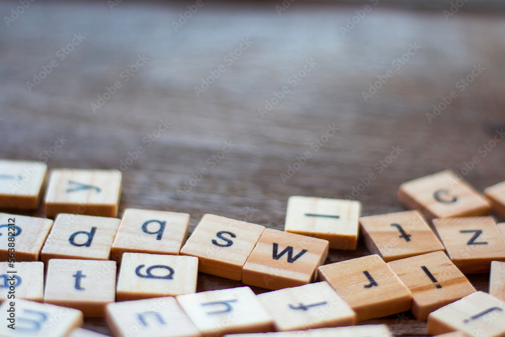 English alphabet made of square wooden tiles with the English alphabet scattered on table. The concept of thinking development, grammar