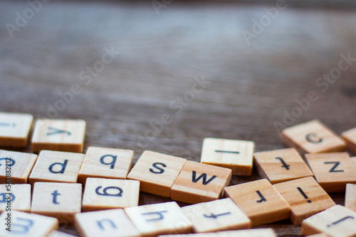 English alphabet made of square wooden tiles with the English alphabet scattered on table. The concept of thinking development, grammar photo