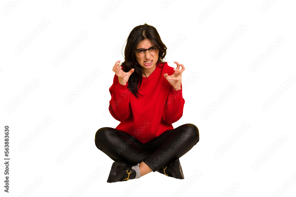 Young indian woman sitting on the floor cut out isolated upset screaming with tense hands. Young indian woman sitting on the floor cut out isolated upset screaming with tense hands.