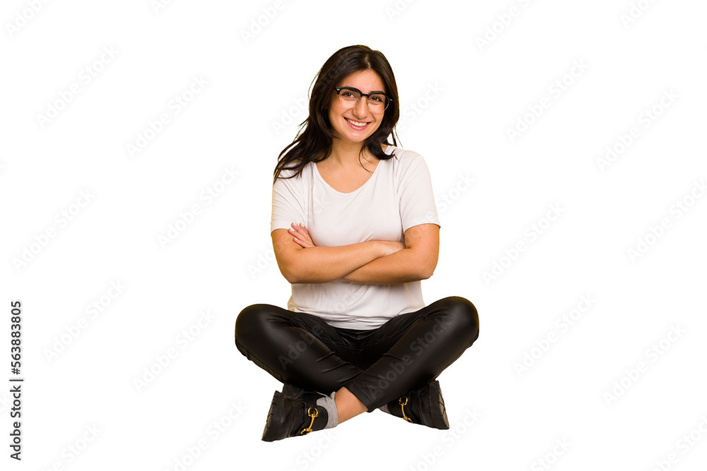 Young indian woman sitting on the floor cut out isolated who feels confident, crossing arms with determination. Young indian woman sitting on the floor cut out isolated who feels confident, crossing arms with determination.