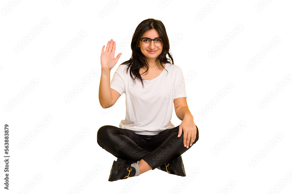 Young indian woman sitting on the floor cut out isolated smiling cheerful showing number five with fingers. Young indian woman sitting on the floor cut out isolated smiling cheerful showing number five with fingers.