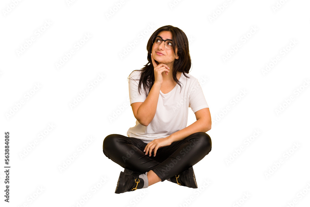 Young indian woman sitting on the floor cut out isolated contemplating, planning a strategy, thinking about the way of a business.
