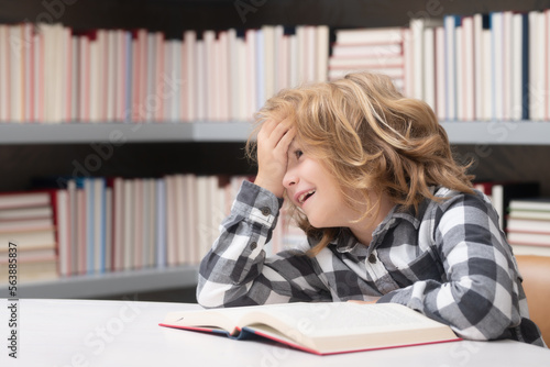 Childhood and education concept. Child reading book in a book store or library,