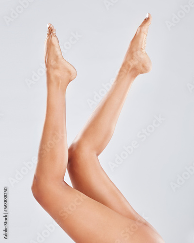 Woman  skincare and beauty of legs for moisturizer isolated on a grey studio background. Female leg and feet in the air for smooth  soft or cosmetic treatment in dermatology  glow or pedicure