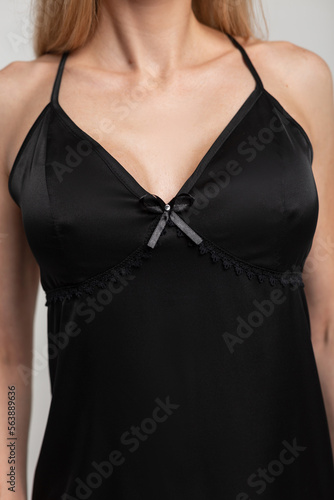 Beautiful female body in fashionable black nightwear dress with lace, close-up.