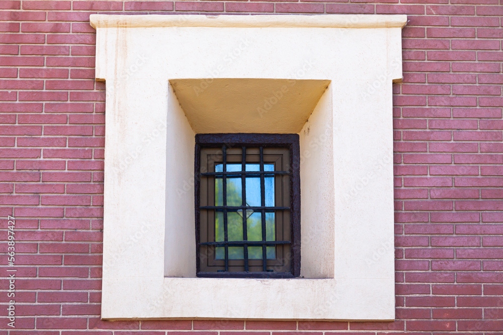 Obraz premium A window with rusty bars on it in an old brick building, close-up.
