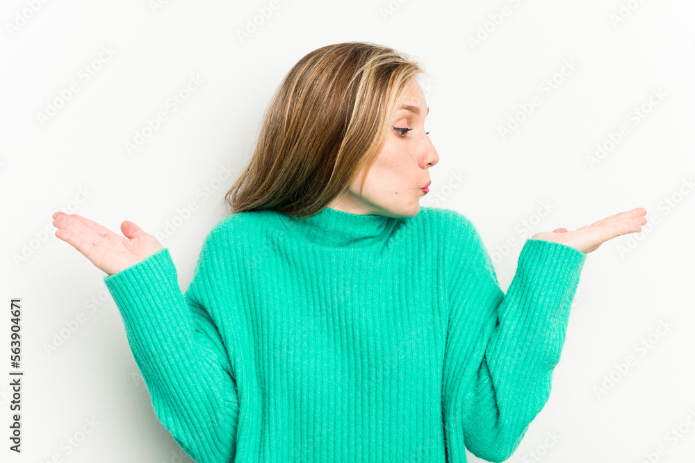 Young caucasian woman isolated on white background confused and doubtful shrugging shoulders to hold a copy space. Young caucasian woman isolated on white background confused and doubtful shrugging shoulders to hold a copy space.