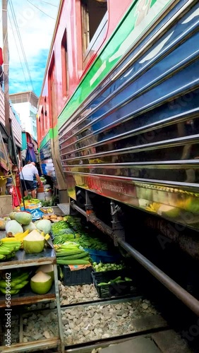 Maeklong Railway Market with trains and people selling stuff on the market in Bangkok Thailand. Train market in Bangkok photo