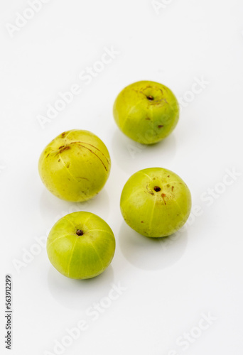 Indian gooseberry or amla fruit and juice having detox properties served in small glasses. photo
