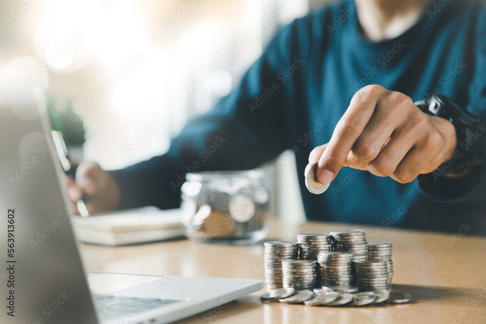 Fototapeta premium Man hands putting coins stack, Concept business finance saving money and investment.