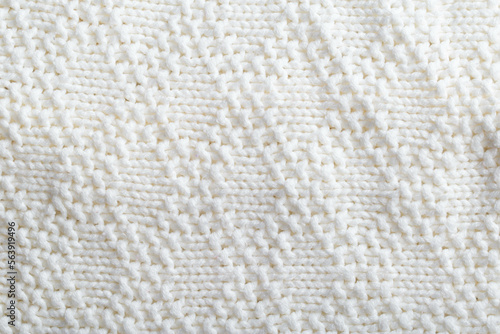 Comfortable warm knitted sweater made of white threads, background. Macro, handmade