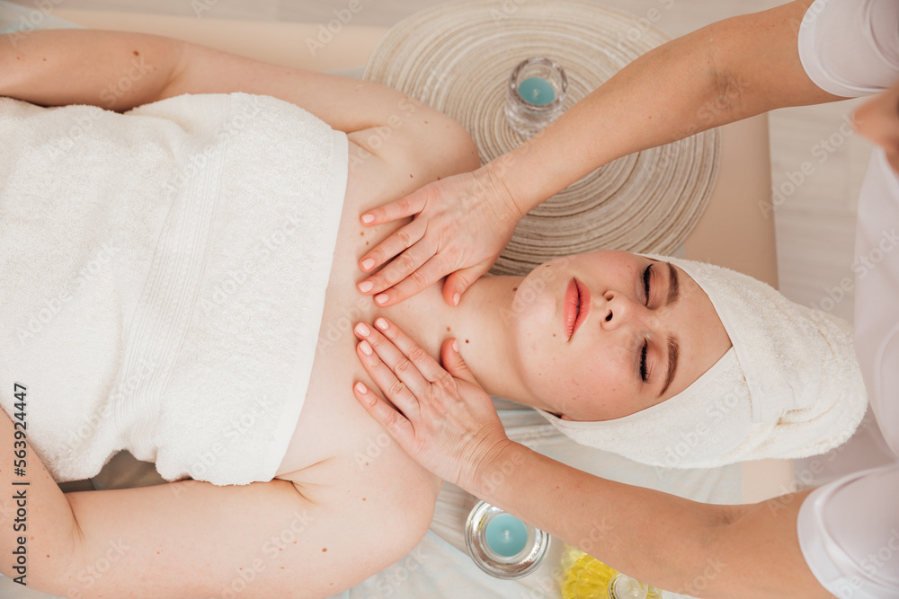 makes a spa massage for a woman in the face and neck makes a spa massage for a woman in the face and neck