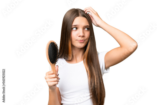 Teenager caucasian girl with hair comb over isolated background having doubts and with confuse face expression