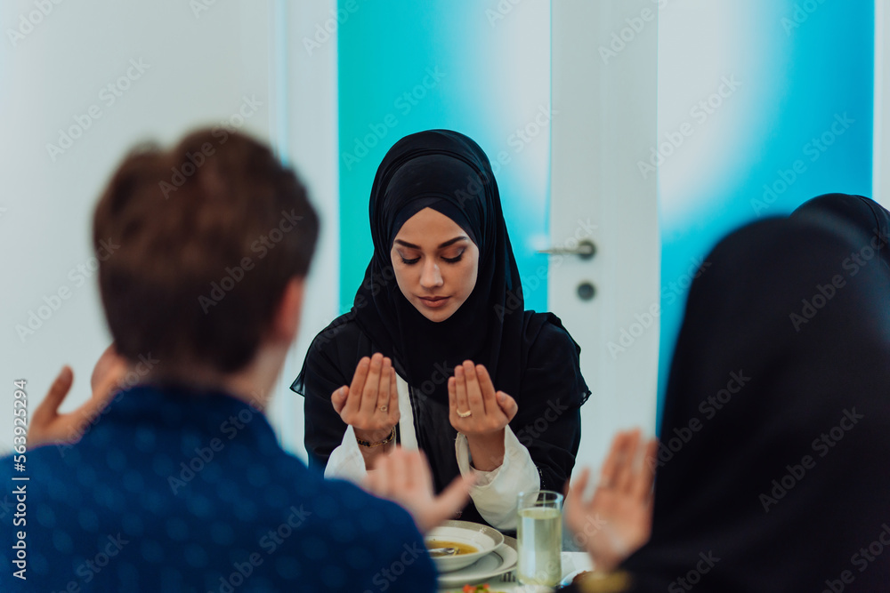 A Muslim family praying together, the Muslim prayer after breaking the fast in the Islamic holy month of Ramadan A Muslim family praying together, the Muslim prayer after breaking the fast in the Islamic holy month of Ramadan