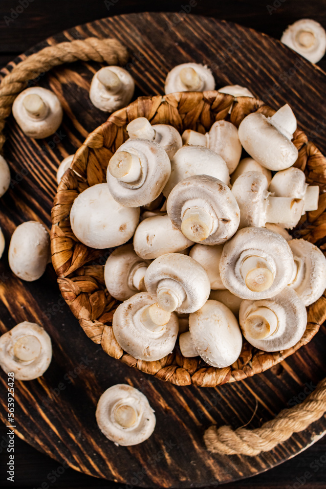 Fresh mushrooms in a basket on a wooden tray. Fresh mushrooms in a basket on a wooden tray.