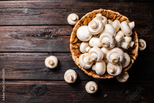 Basket with fresh mushrooms. On a wooden background. 