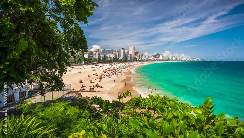 A timelapse of beachgoers in Rio de Janeiro, Brazil playing on the sand and in the water of the Atlantic Ocean at Leblon, near Ipanema and Copacabana.