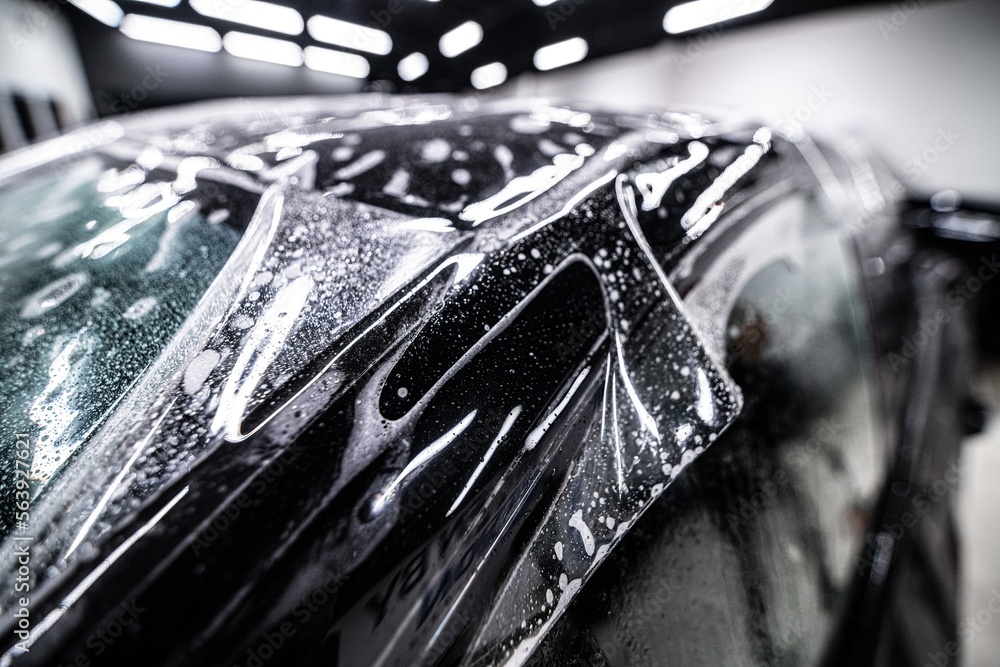Colorless protective ppf film on the roof of a modern car. The foil protects the car paint from scratches and fading. Car detailing studio