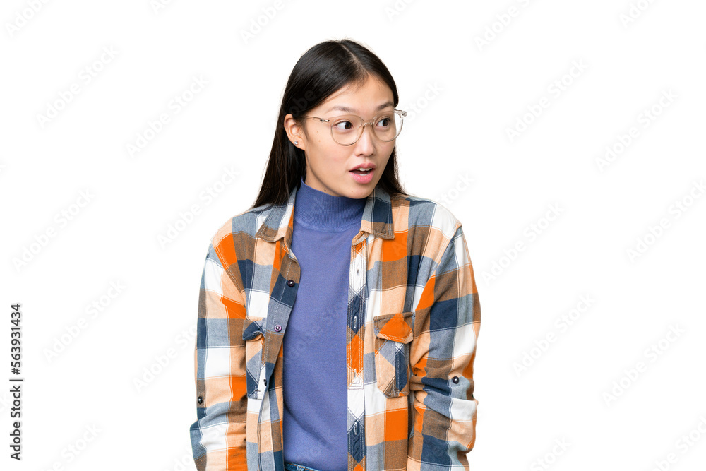 Young Asian woman over isolated chroma key background doing surprise gesture while looking to the side Young Asian woman over isolated chroma key background doing surprise gesture while looking to the side