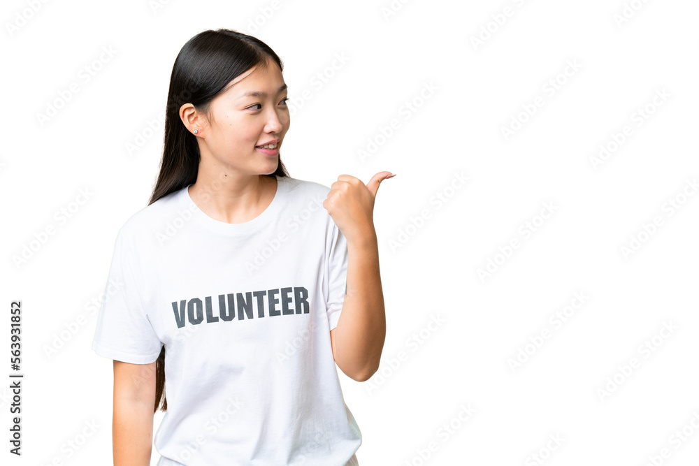 Young volunteer woman over isolated chroma key background pointing to the side to present a product Young volunteer woman over isolated chroma key background pointing to the side to present a product