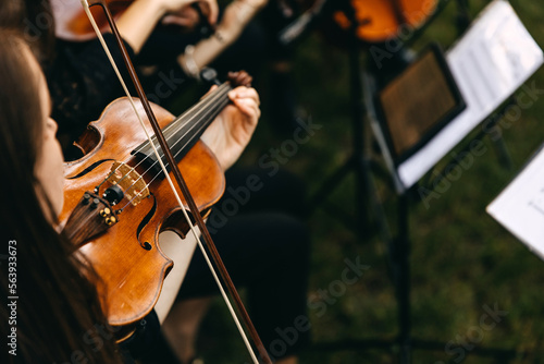 Closeup of a musician playing violin, outdoors.
