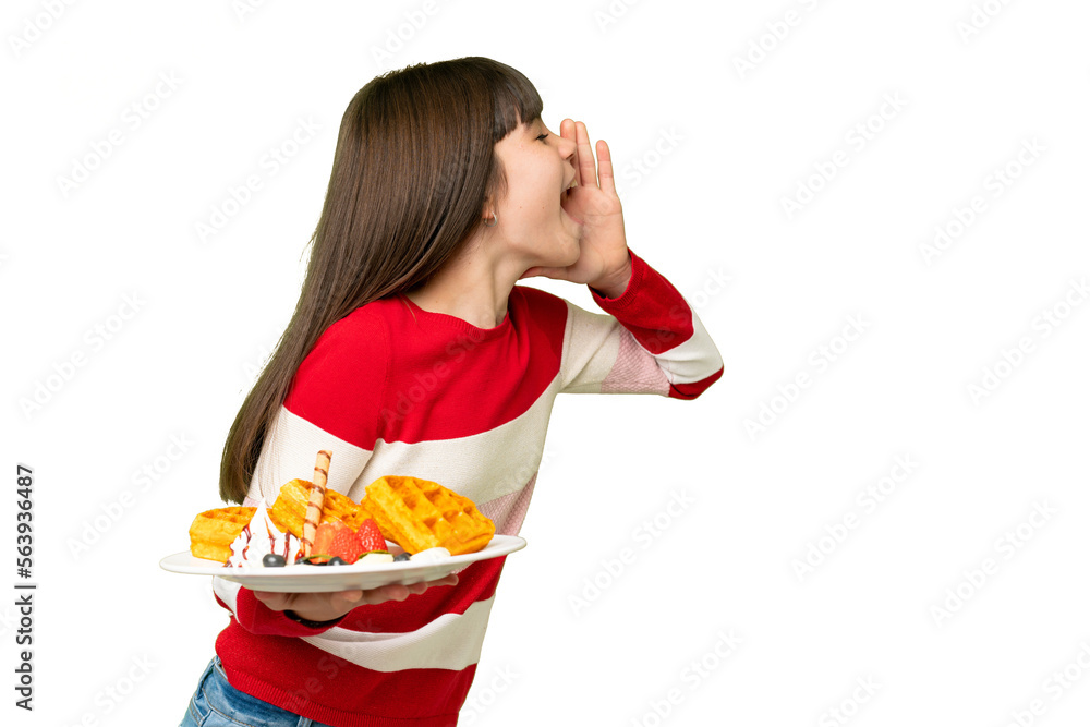Little girl holding waffles over isolated chroma key background shouting with mouth wide open to the side Little girl holding waffles over isolated chroma key background shouting with mouth wide open to the side