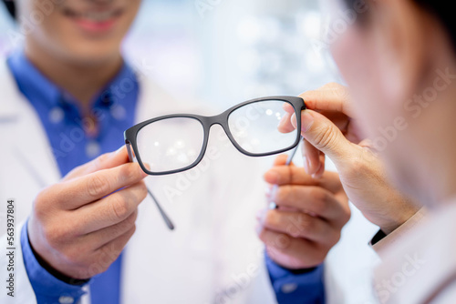 optometrist giving new glasses. Help in choosing eyeglasses.