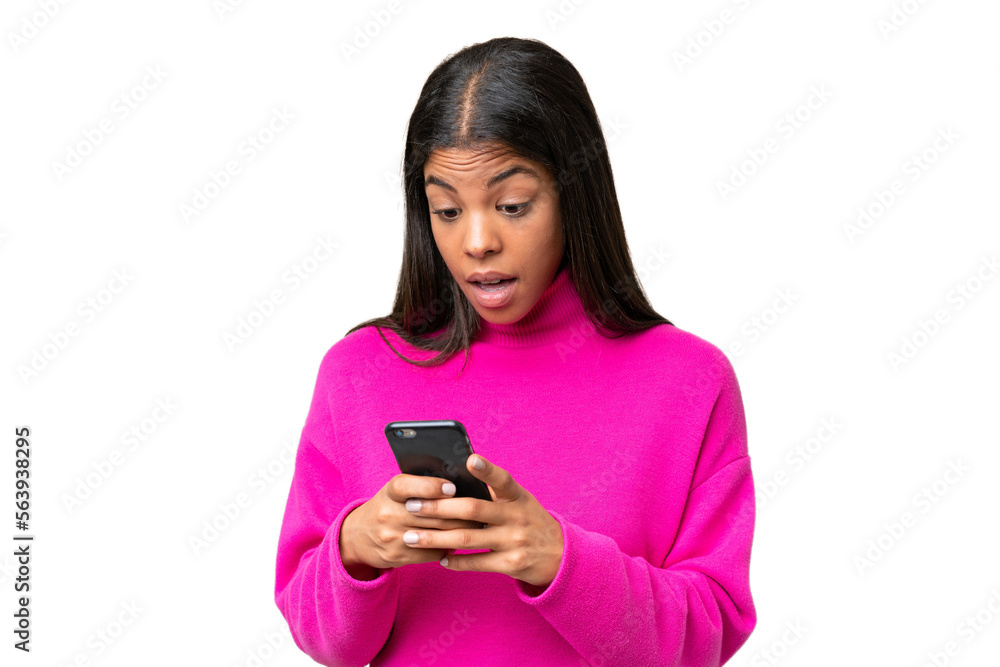 Young African American woman over isolated background looking at the camera while using the mobile with surprised expression Young African American woman over isolated background looking at the camera while using the mobile with surprised expression